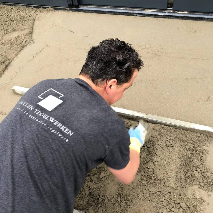 Tonnie van Engelen aan het werk als tegelzetter